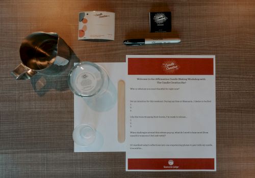 A setup with a pitcher, glass, notepad, pen, and paper containing text, organized neatly on a table.